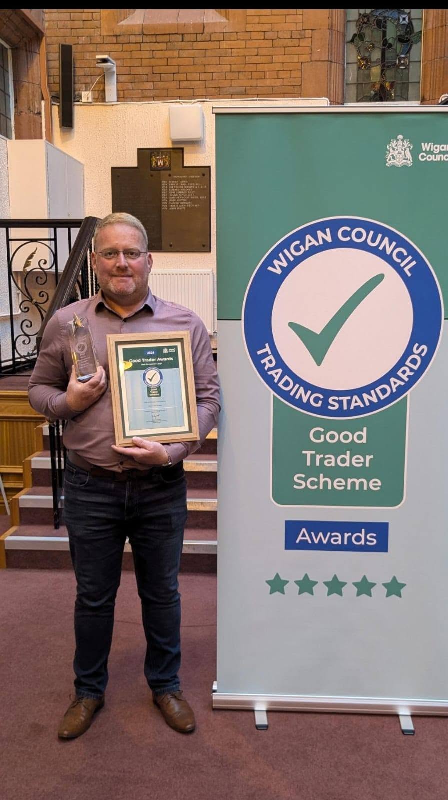 Andy holding a Wigan Council Good Trader award